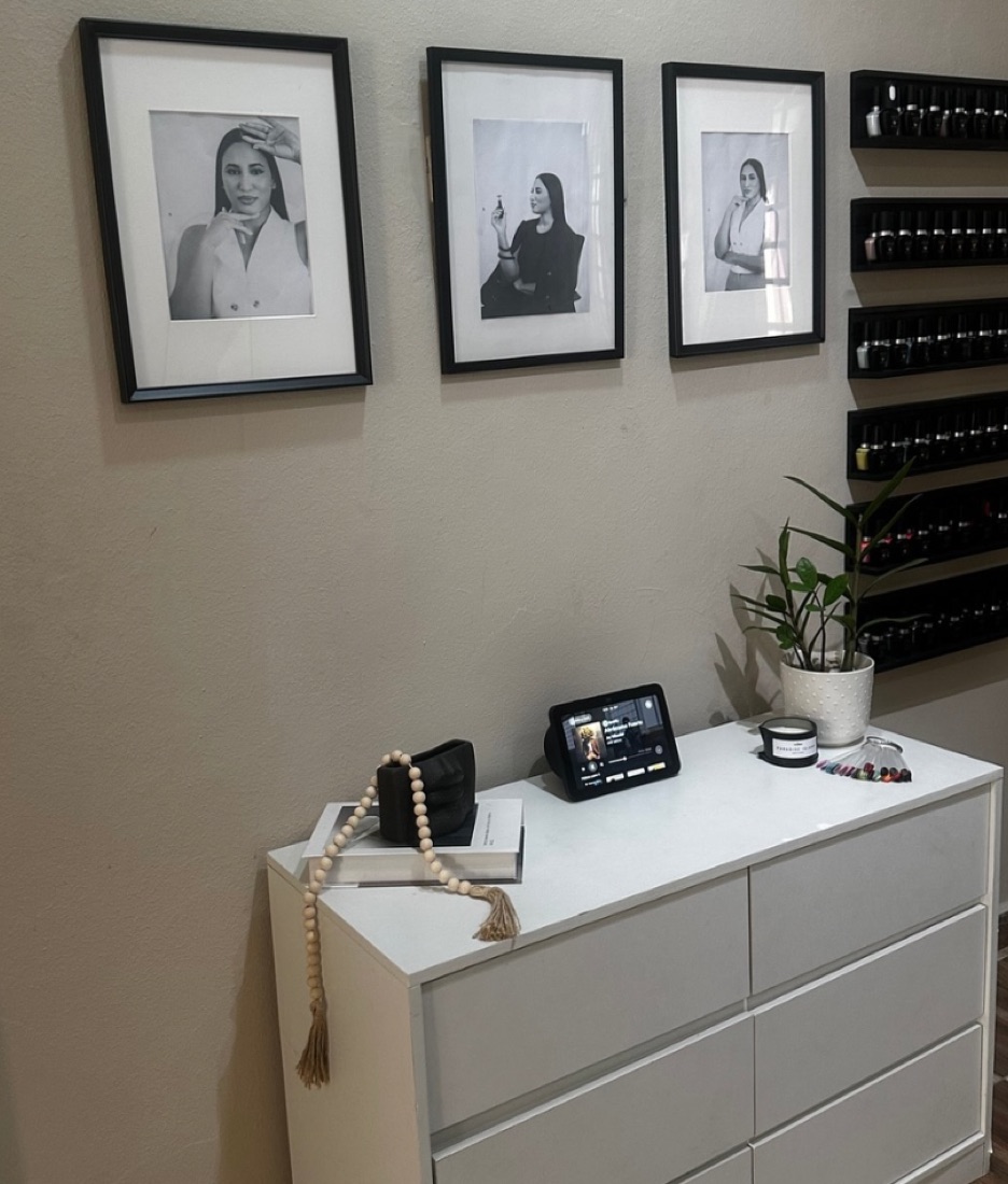 Pared del estudio con los retratos de Dalfina Guzmán y los estantes de esmaltes